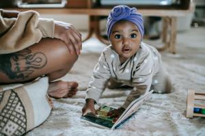 baby with book next to mom